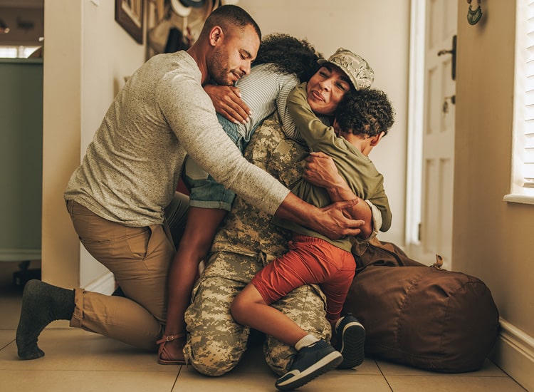A soldier finding support for anxiety through the embrace of his family in a comfortable living room setting.