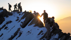 At sunrise, a group of people in camouflage uniforms trek up the snowy, rocky mountain slope, their footsteps deliberate and determined as if navigating a VA higher level review process.