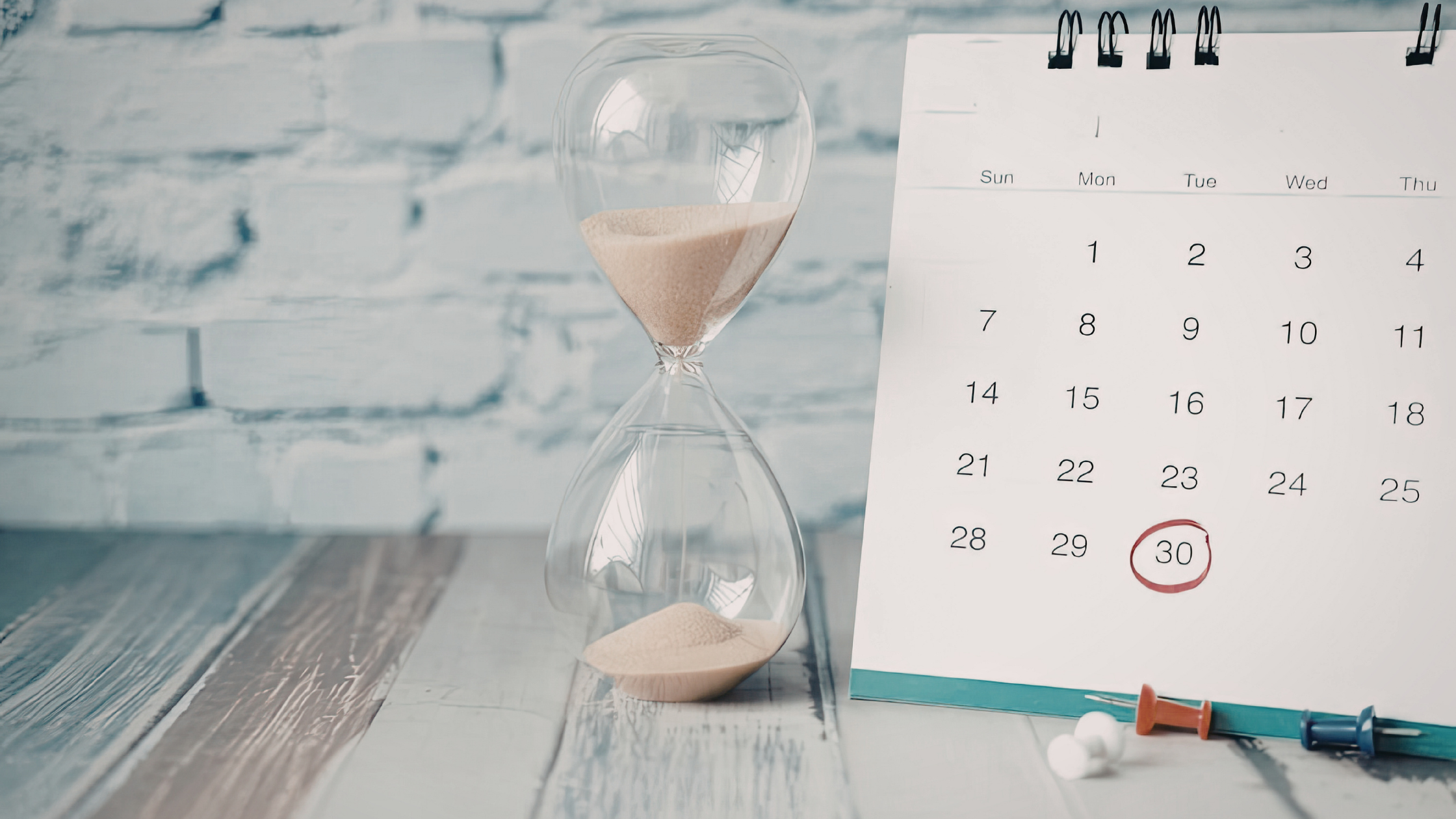 Hourglass beside a calendar with a circled date, representing the importance of submitting an intent to file VA form to preserve the effective date for a VA disability claim.