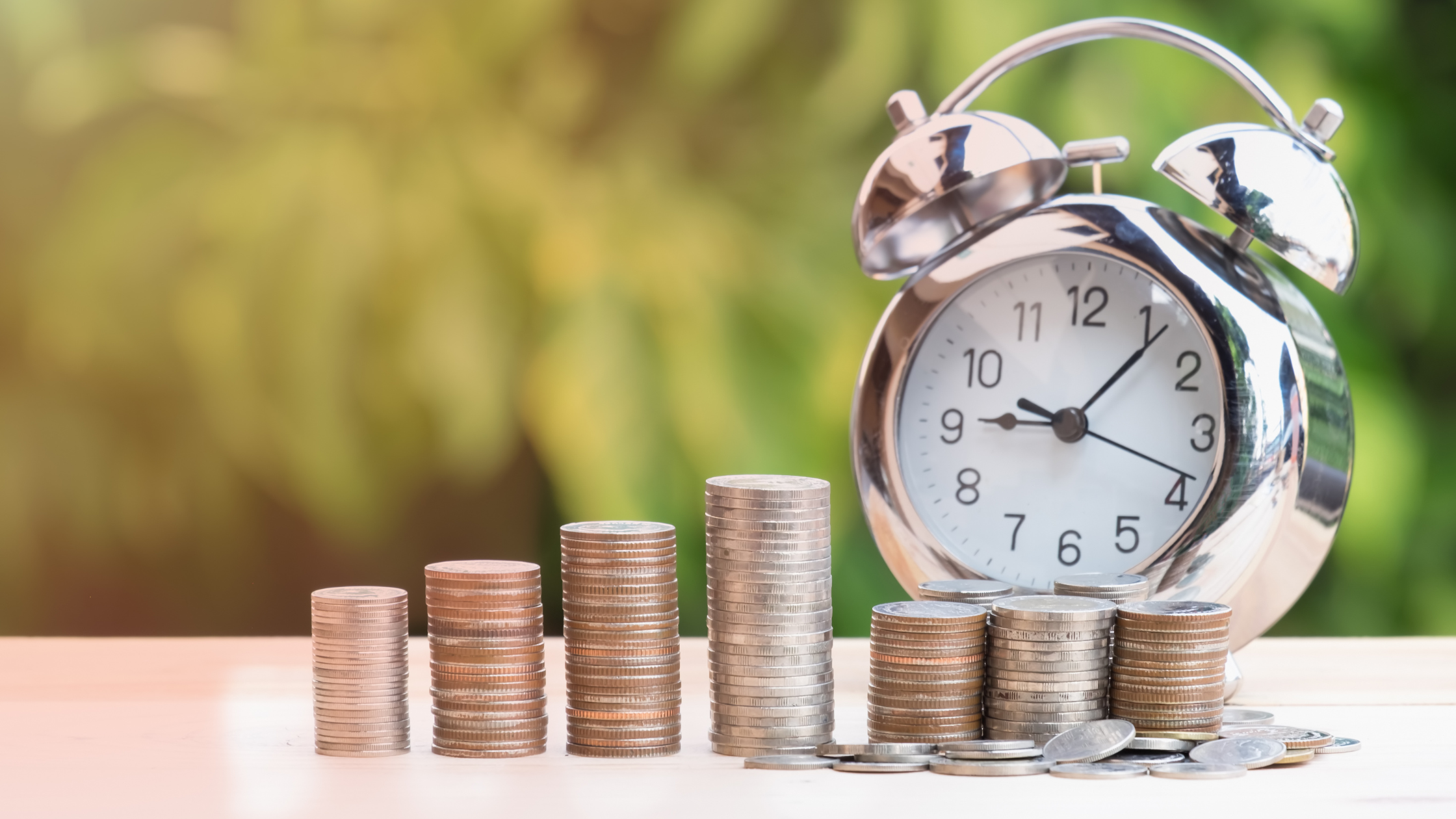 Stacks of coins beside an alarm clock representing VA back pay and retroactive VA disability compensation owed from an earlier effective date.